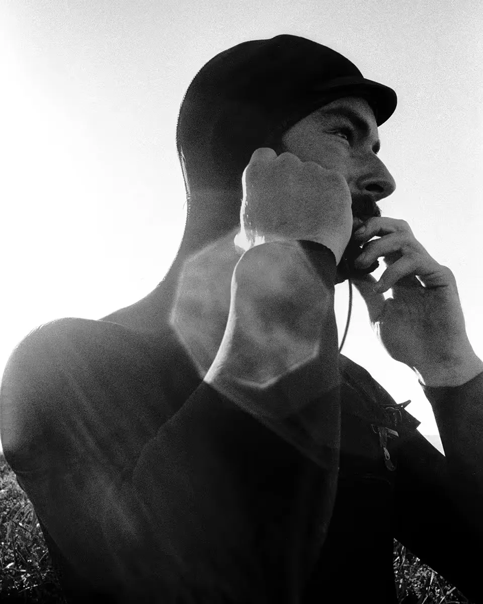Man in wetsuit, backlit by bright sky